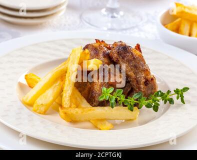 Grillrippen mit französischen Bratkartoffeln serviert. Stockfoto