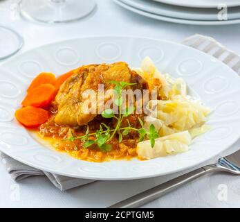 Gebratenes Huhn in Sauce mit Gemüse serviert. Stockfoto