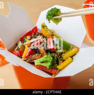 Köstliche vegetarische Gerichte zum Mitnehmen in einem Karton mit Essstäbchen. Stockfoto