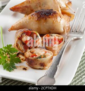 Kalamaria Gemista ist ein griechisches Rezept für gefüllte Tintenfische mit Reis und Kräutern in Tomatensauce. Stockfoto