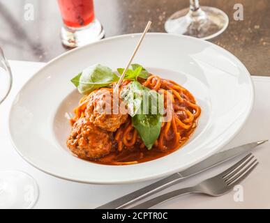 Spaghetti und Fleischbällchen Gericht mit Tomatensauce und Basilikumblättern. Stockfoto