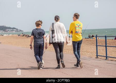 Eine Familie, die entlang einer Strandpromenade während der covid-19 Einschränkungen geht Stockfoto