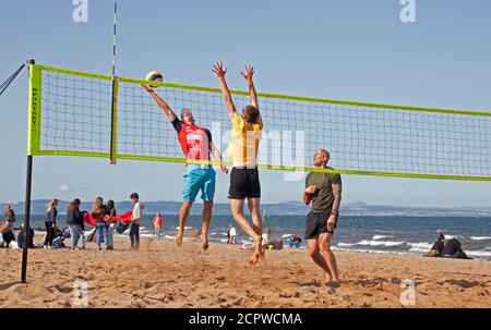 UK Wetter: Portobello Beach, Edinburgh, Schottland. 19. September 2020. Heute Nachmittag zieht das Meer immer noch Menschenmassen an, um das sonnige Wetter zu genießen, obwohl der kühle Wind die Temperatur wie 14 Grad gegenüber der tatsächlichen Temperatur von 16 Grad anfühlt. Im Bild: Ein Gemeinschaftsgruppen-Volleyballteam freut sich, wieder zur Aktivität zu kommen. Stockfoto
