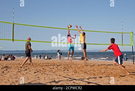 UK Wetter: Portobello Beach, Edinburgh, Schottland. 19. September 2020. Heute Nachmittag zieht das Meer immer noch Menschenmassen an, um das sonnige Wetter zu genießen, obwohl der kühle Wind die Temperatur wie 14 Grad gegenüber der tatsächlichen Temperatur von 16 Grad anfühlt. Im Bild: Ein Gemeinschaftsgruppen-Volleyballteam freut sich, wieder zur Aktivität zu kommen. Stockfoto