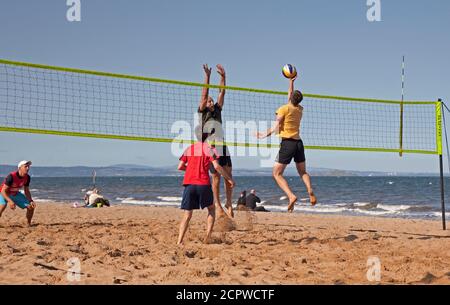 UK Wetter: Portobello Beach, Edinburgh, Schottland. 19. September 2020. Heute Nachmittag zieht das Meer immer noch Menschenmassen an, um das sonnige Wetter zu genießen, obwohl der kühle Wind die Temperatur wie 14 Grad gegenüber der tatsächlichen Temperatur von 16 Grad anfühlt. Im Bild: Ein Gemeinschaftsgruppen-Volleyballteam freut sich, wieder zur Aktivität zu kommen. Stockfoto