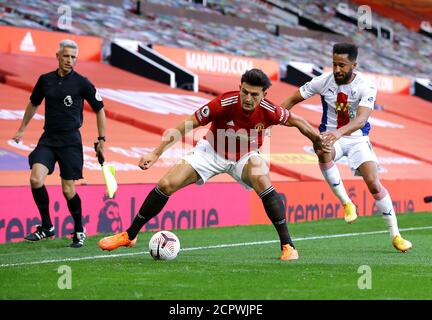 Harry Maguire von Manchester United und Andros Townsend von Crystal Palace (rechts) kämpfen während des Premier League-Spiels in Old Trafford, Manchester, um den Ball. Stockfoto