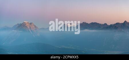 Blick auf die hohe Munde (2662 m) und die Zugspitze (2962 m) im Karwendelgebirge kurz nach Sonnenaufgang. Stockfoto