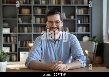 Porträt eines lächelnden Millennials Mann sitzen am Schreibtisch Stockfoto