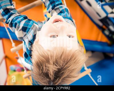 Kleiner Junge kriecht im metallischen Heim-gegründeten Sportzentrum Stockfoto