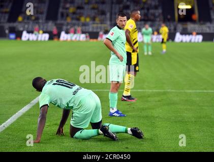 Dortmund, Deutschland. September 2020. Fußball: Bundesliga, Borussia Dortmund - Borussia Mönchengladbach, 1. Spieltag im Signal Iduna Park. Mönchengladbachs Marcus Thuram kniet nach einem Duell im 16 Meter großen Gelände auf dem Gras. WICHTIGER HINWEIS: Gemäß den Bestimmungen der DFL Deutsche Fußball Liga und des DFB Deutscher Fußball-Bund ist es untersagt, im Stadion und/oder aus dem Spiel aufgenommene Aufnahmen in Form von Sequenzbildern und/oder videoähnlichen Fotoserien zu verwenden oder zu verwenden. Quelle: Bernd Thissen/dpa/Alamy Live News Stockfoto