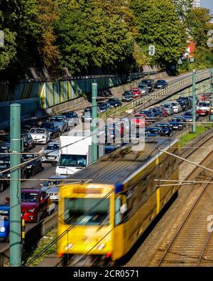 Verkehrsstau auf der Autobahn A40 und freie Fahrt mit der U-Bahn U18, Essen, Ruhrgebiet, Nordrhein-Westfalen, Deutschland Stockfoto