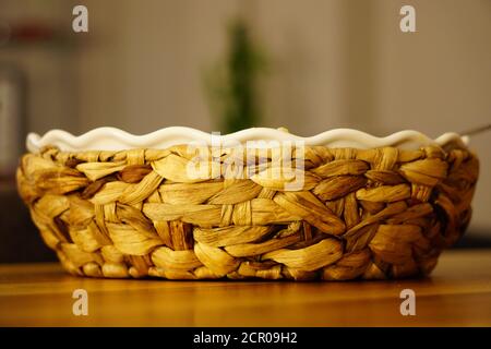 Keramikschale mit Strohmatte Gehäuse auf Holzhintergrund mit Geringe Schärfentiefe Stockfoto