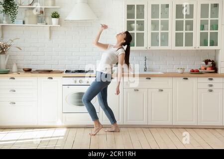 Junge Frau mit Spaß in der gemütlichen Küche Stockfoto