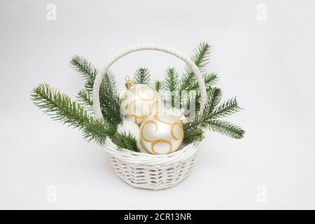 Weihnachtlicher weißer Korb mit trendigen vergoldeten Weihnachtsbaumkugeln Stockfoto