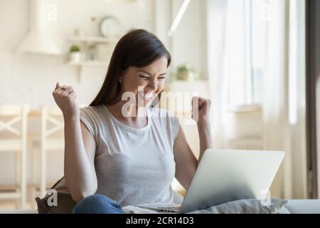 Junge Frau glücklich über gute Nachrichten per E-Mail erhalten Stockfoto