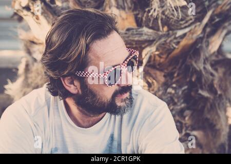 Schöner Erwachsener kaukasischen Mann Porträt im Freien mit alternativen Sonnenbrillen Und Bart Stockfoto