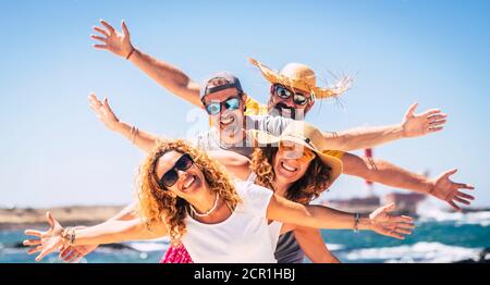 Gruppe von glücklichen Menschen genießen Reisen und Sommerurlaub Urlaub Gemeinsam Spaß unter der Sonne - blaues Meerwasser Im Hintergrund und Himmel - freudig Stockfoto