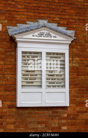 Eine Tafel vor dem Jockey Club informiert Besucher darüber, welche Galopps in Newmarket, High Street, Newmarket, Suffolk, Großbritannien geöffnet sind. Stockfoto