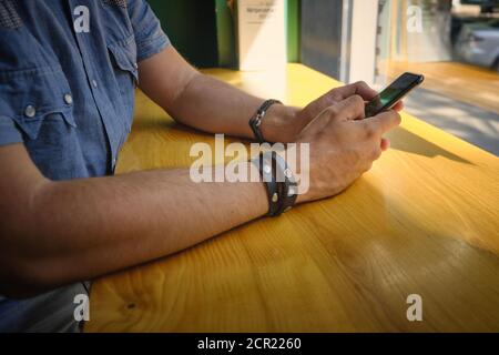 Hände des Mannes halten Telefon und chatten online Stockfoto