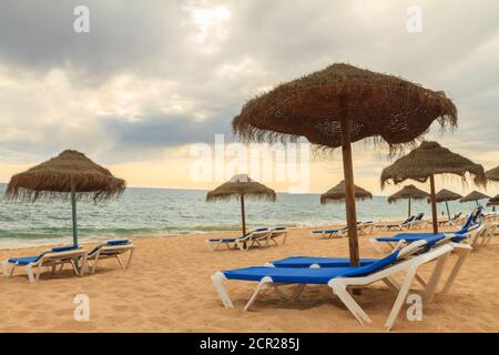 Leerer einsamer Strand mit niemand in den Liegestühlen in Faro, Algarve während der Covid-19 Pandemiebeschränkungen. Stockfoto