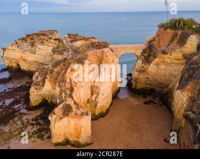 Strand Praia dos Estudantes bei Sonnenuntergang mit Bogenbrücke in Lagos, Algarve, Portugal Stockfoto