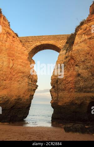 Strand Praia dos Estudantes bei Sonnenuntergang mit Bogenbrücke in Lagos, Algarve, Portugal Stockfoto