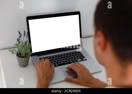 Zugeschnittenes Bild eines jungen Mannes, der in einem Café an seinem Laptop arbeitet, Rückansicht eines Geschäftsmanns, der am Schreibtisch mit dem Laptop beschäftigt ist, junger Mann Stockfoto