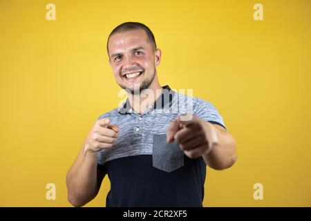 Russischer Mann stand über versohlten gelben Hintergrund zeigt Finger zur Kamera mit glücklichen und lustigen Gesicht. Gute Energie und Vibes. Stockfoto