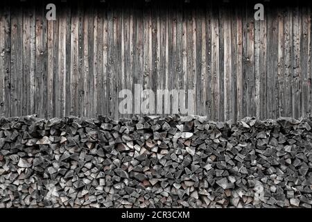 Brennholz vor einer verwitterten Holzwand Stockfoto