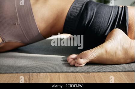 Liegend Held Pose (Supta Virasana), iyengar Yoga Asana Frau Nahaufnahme Stockfoto