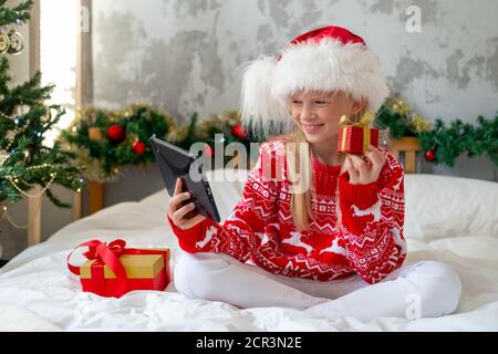 Weihnachten online Herzlichen Glückwunsch. Lächelnde Frau mit mobilen Tablet für Videoanruf Freunde und Eltern Stockfoto