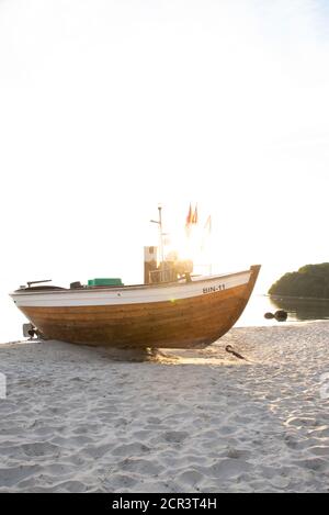 Deutschland, Mecklenburg-Vorpommern, Rügen, Ostseebad Binz, ein altes Fischerboot liegt am Strand in grellem Sonnenlicht Stockfoto