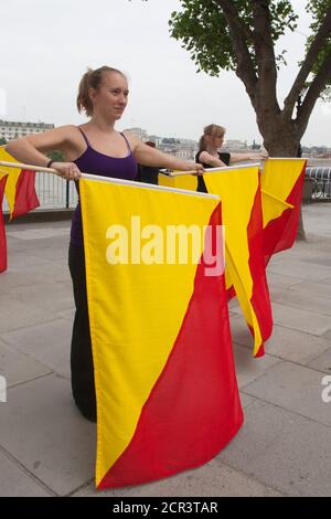 Probe für die Semaphore-Flaggen-Botschaft an HM the Queen für den Thames Diamond Jubilee Pageant. Southbank Centre hat Artist in Residence Lea Anderson beauftragt, ein neues Werk zu choreografieren - als die Flottille am 3. Juni am Southbank Centre vorbeigeht, 30 Tänzer werden auf dem Dach der Royal Festival Hall sein, um HM der Königin eine besondere Botschaft mit Semaphore-Fahnen in rot und gelb zu senden. Die Botschaft wird buchstabieren: Happy Diamond Jubilee Queen Elizabeth, Wir Herzen dich. Stockfoto