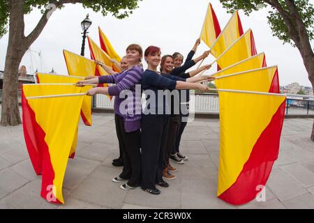 Probe für die Semaphore-Flaggen-Botschaft an HM the Queen für den Thames Diamond Jubilee Pageant. Southbank Centre hat Artist in Residence Lea Anderson beauftragt, ein neues Werk zu choreografieren - als die Flottille am 3. Juni am Southbank Centre vorbeigeht, 30 Tänzer werden auf dem Dach der Royal Festival Hall sein, um HM der Königin eine besondere Botschaft mit Semaphore-Fahnen in rot und gelb zu senden. Die Botschaft wird buchstabieren: Happy Diamond Jubilee Queen Elizabeth, Wir Herzen dich. Stockfoto