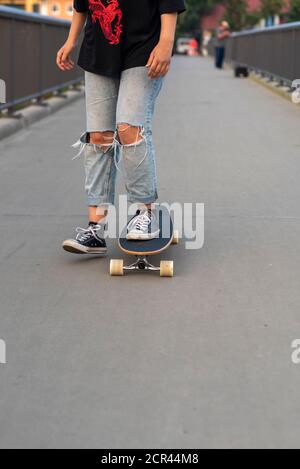 Mädchen reitet ein Longboard auf einer Brücke Stockfoto