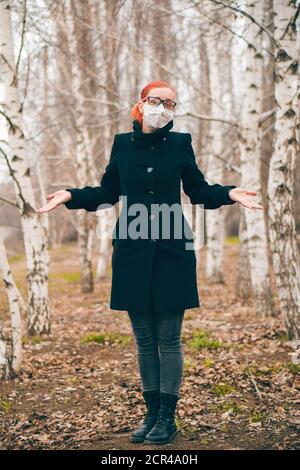 Maskiertes Mädchen mit Brille zuckt draußen. Schutz vor Viren-Konzept. Stockfoto