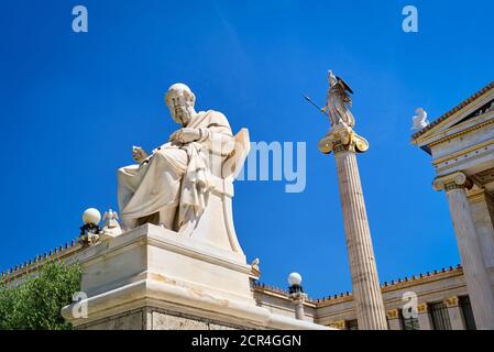 Statue von Plato, große antike griechische Philosoph, sitzt in Stuhl und Spalte mit Statue der Athena, alte griechische Göttin. Akademie von Athen, Griechenland. Stockfoto