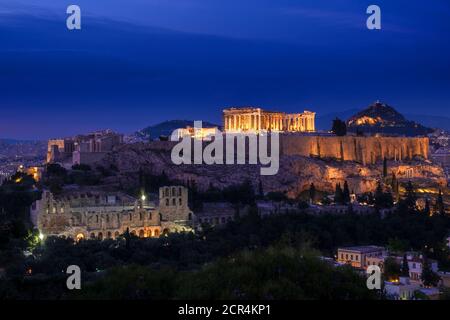 Ikonische Ansicht des Akropolis Hügels in Athen, Griechenland bei Nacht. Zarte Lichter von Parthenon und Odeon Theater. UNESCO-Weltkulturerbe. Stockfoto