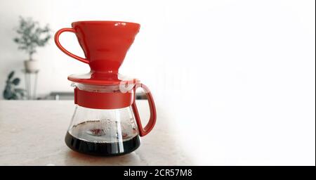 Pourover. V60. Frischer, heißer Kaffeefilter tropft in den Glasserver Stockfoto