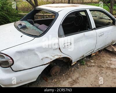 Metallschrott, zerbrochene, verlassene weiße Autos ohne Räder und Fenster Stockfoto