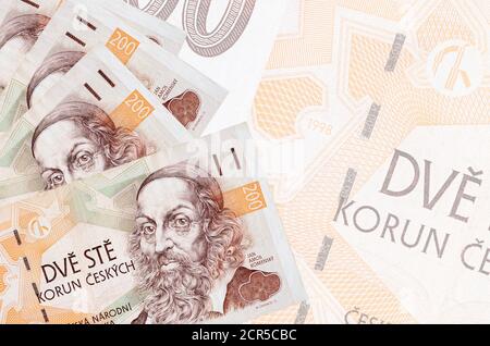 200 tschechische korun-Scheine liegen im Stapel auf dem Hintergrund der großen halbtransparenten Banknote. Abstrakter Geschäftshintergrund mit Kopierbereich Stockfoto