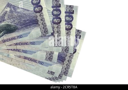 100 philippinische Piso Bills liegt in kleinen Haufen oder Packung isoliert auf weiß. Mockup mit Kopierbereich. Business- und Wechselkonzept Stockfoto