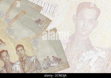 1000 Thai Baht Scheine liegt im Stapel auf dem Hintergrund der großen halbtransparenten Banknote. Abstrakter Geschäftshintergrund mit Kopierbereich Stockfoto