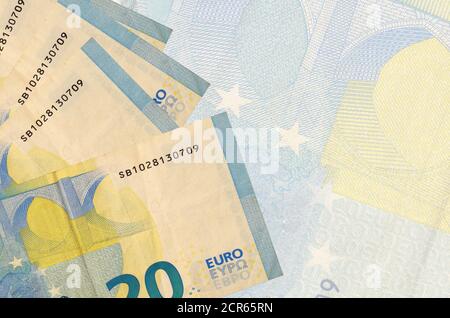 20 Euro Scheine liegen im Stapel auf dem Hintergrund der großen halbtransparenten Banknote. Abstrakter Geschäftshintergrund mit Kopierbereich Stockfoto