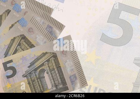 5 Euro Scheine liegen im Stapel auf dem Hintergrund der großen halbtransparenten Banknote. Abstrakter Geschäftshintergrund mit Kopierbereich Stockfoto