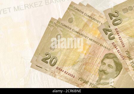 20 Türkische Lira-Scheine liegen auf dem Hintergrund einer großen halbtransparenten Banknote im Stapel. Abstrakte Darstellung der nationalen Währung. Geschäftskonzept Stockfoto