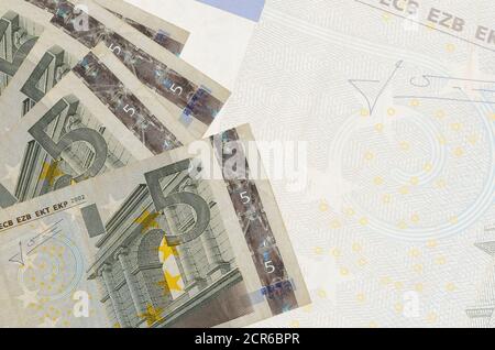 5 Euro Scheine liegen im Stapel auf dem Hintergrund der großen halbtransparenten Banknote. Abstrakter Geschäftshintergrund mit Kopierbereich Stockfoto
