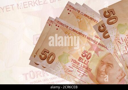 50 Türkische Lira-Scheine liegen auf dem Hintergrund einer großen halbtransparenten Banknote im Stapel. Abstrakte Darstellung der nationalen Währung. Geschäftskonzept Stockfoto