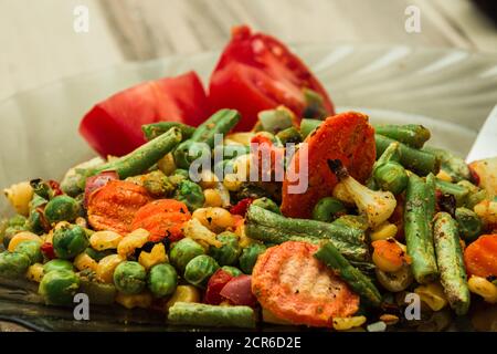 Mischung aus gesundem gekochtem Gemüse und Tomatenstücken Stockfoto