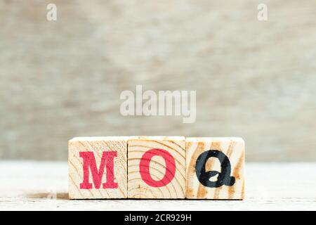 Buchstabenblock im Wort MOQ (Abkürzung für Mindestbestellmenge) auf Holzhintergrund Stockfoto
